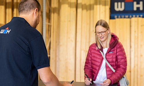 WH-Mitarbeiter berät Kundin in der Holzabteilung